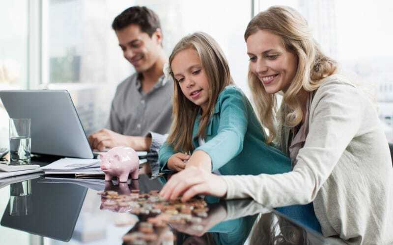 Young couple with child counting coins at a table